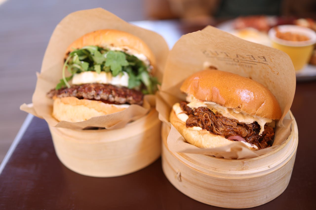 Close-up of gourmet beef burgers served in bamboo steamers, perfect for food photography.